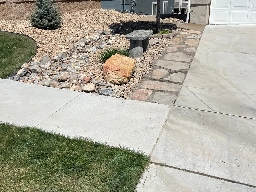 Flagstone walk and xeriscape bed beside a front driveway
