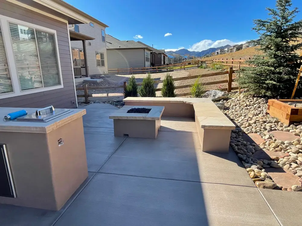 Outdoor kitchen counter, fire table and seat wall with a view of the foothills