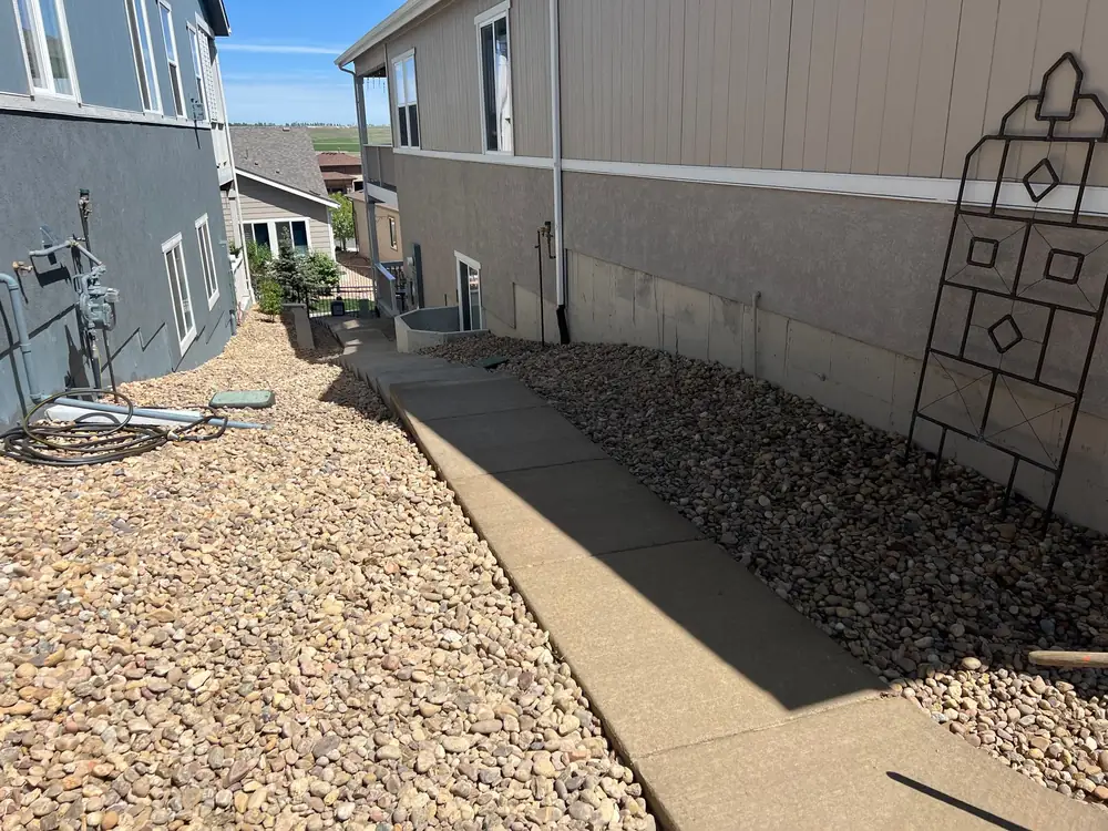 Concrete side-yard walk with river rock and gravel