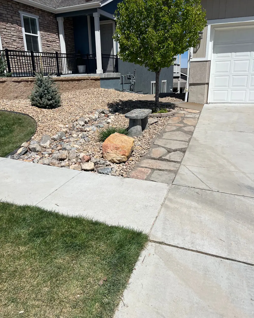 Flagstone walk and xeriscape bed beside a front driveway