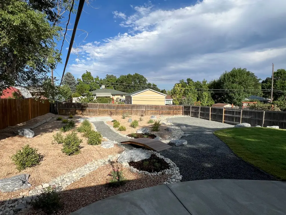 Xeriscaped yard with a dry creek bed, boulders and low-water shrubs